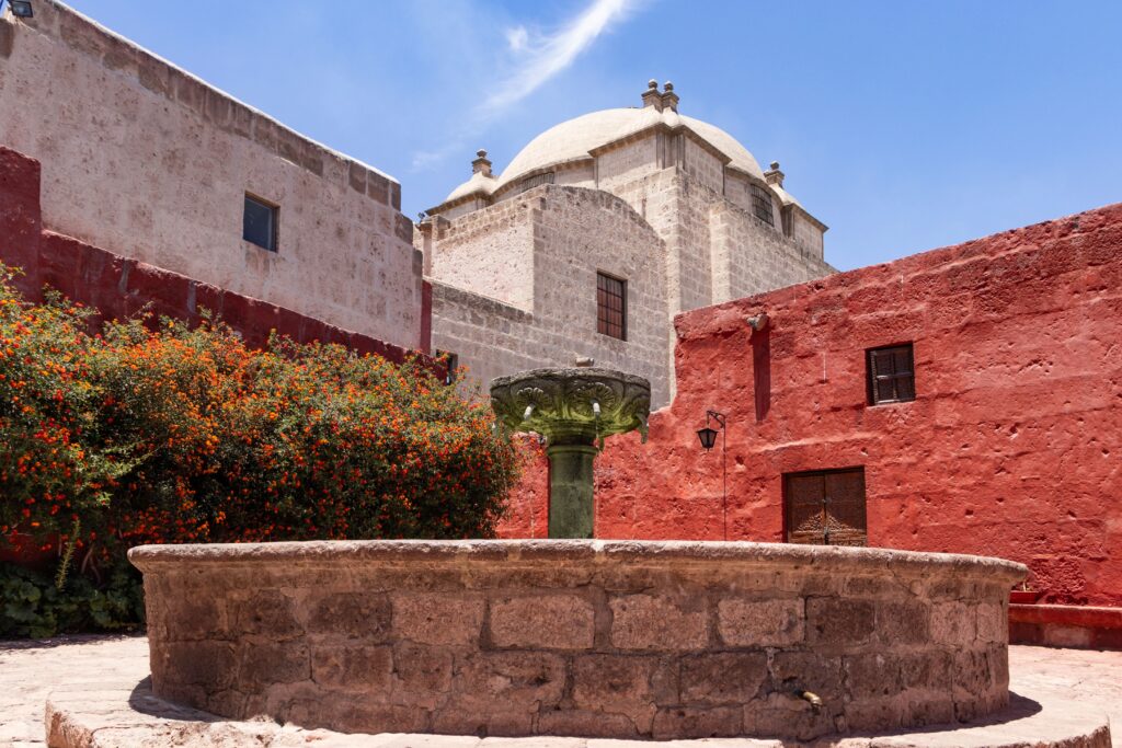 Explore the vivid colonial architecture of Santa Catalina Monastery in Arequipa, Peru, featuring red walls and historical charm.